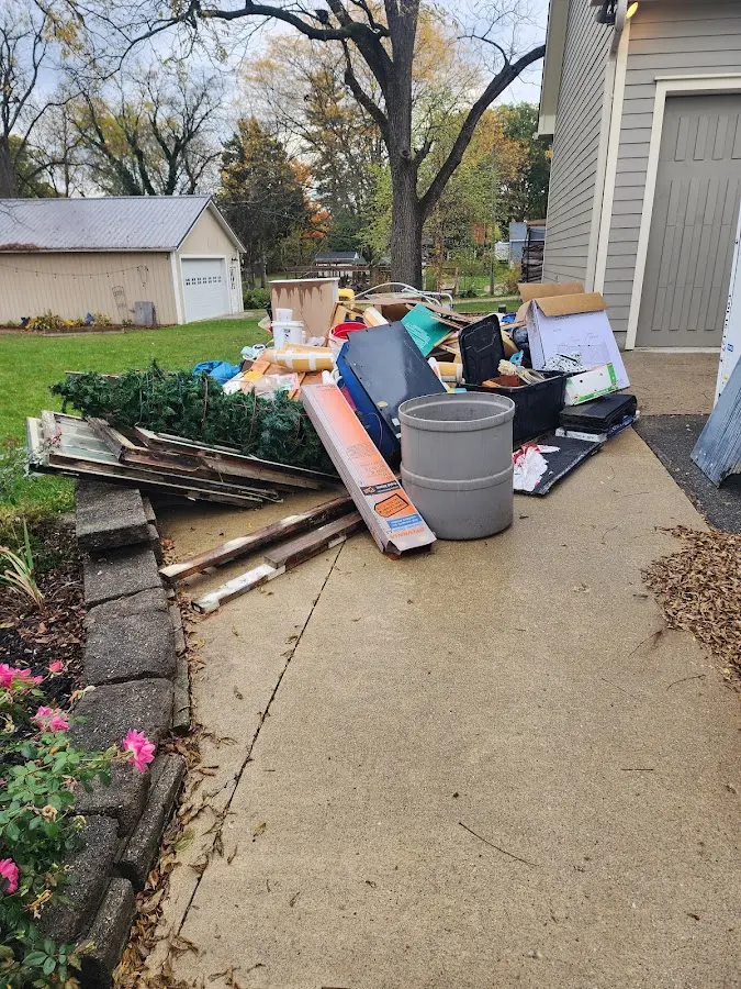 Dumpster being loaded with debris for 12 Yard Dumpster Rental in Mishawaka